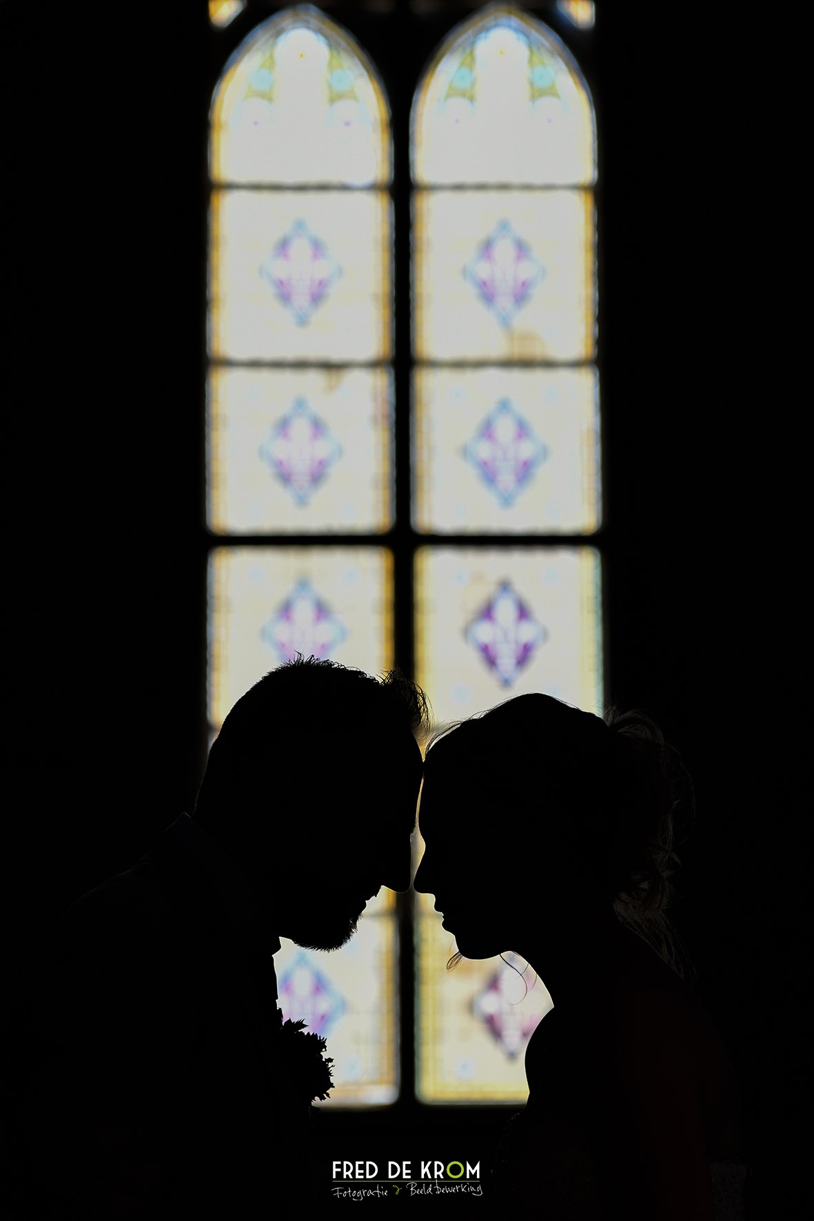 Bruidspaar in kerk voor gebrandschilderde vensters