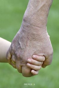 Opa en kleinkind hand in hand.