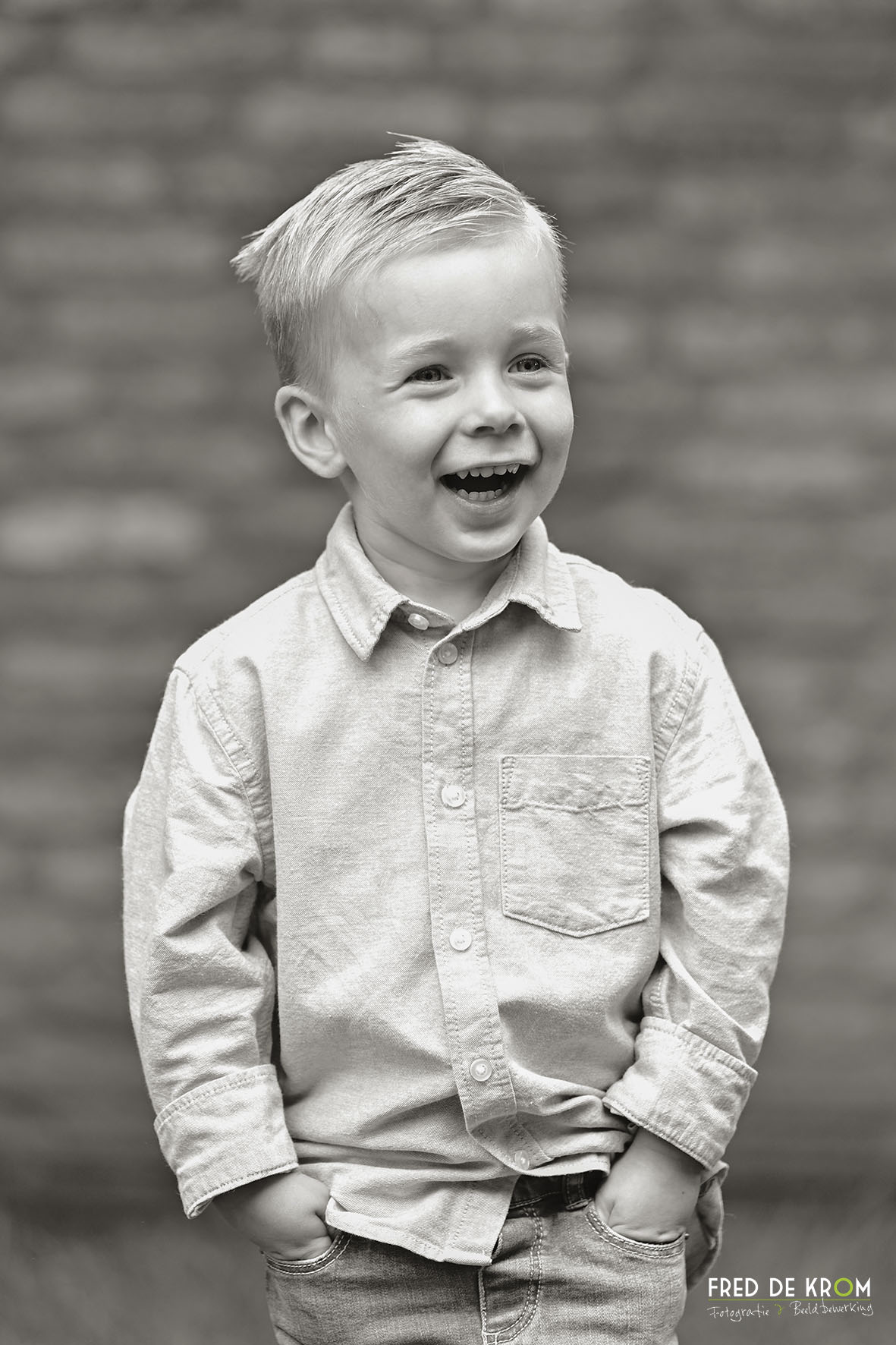 Spontane zwart wit foto van lachend jongetje in Eindhoven.